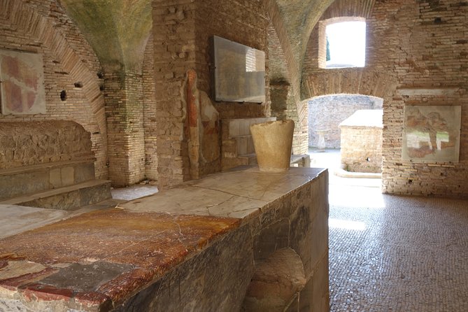 Ancient Ostia Antica Semi-Private Day Trip from Rome by Train with Guide - Amphitheater seats and Roman entertainment energy